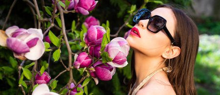 Photo for Vogue fashion style portrait of young girl. Fashion female model with sunglasses outdoor. Magnolia flower background. Beautiful woman face, spring banner for website header - Royalty Free Image