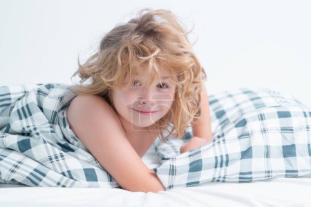 Photo for Child wakes up in the morning in the bedroom. Cute little boy waking up in bed. Healthy sleeping, zzz concept - Royalty Free Image