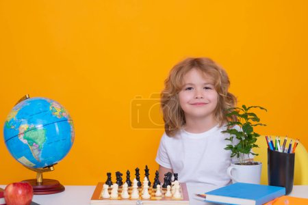 Téléchargez les photos : Kid play chess on isolated studio background. Kid thinking about chess. The concept of learning and growing children. Chess, success and winning. Board logic game, kids hobby and lifestyle - en image libre de droit