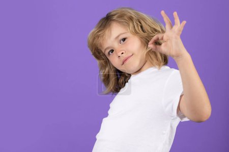 Foto de Portrait of cute smiling child with okay gesture, isolated studio background. Successful kid gesturing, excellent sign, ok gesture - Imagen libre de derechos