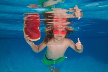 Foto de Child boy with watermelon swim under water in sea. Kid swimming in pool underwater. Happy boy swims in sea underwater, active kid swimming. Summer travelling - Imagen libre de derechos