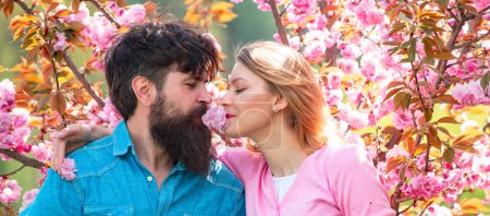 Foto de Couple in love, spring banner. Happy young couple looking at each other and kissing while celebrating Valentines Day - Imagen libre de derechos