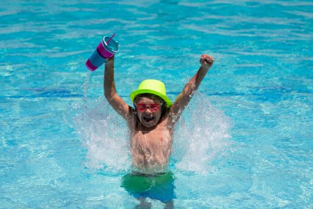 Téléchargez les photos : Kid boy hold healthy fruits and vegetables juice smoothie in summer pool. Happy child enjoying organic drink. Little child boy in swimming pool. Summer vacation - en image libre de droit