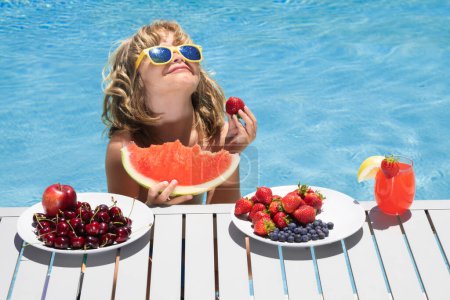 Foto de Child in swimming pool. Kids swim on summer vacation. Portrait of summer kids. Beach sea and water fun. Summer kids cocktail and fruits.Funny amazed kids face - Imagen libre de derechos