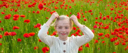 Téléchargez les photos : Spring and kid. Wide photo banner for website header. Portrait of beautiful child girl are wearing casual clothes in field of poppy flowers. Family on spring poppy field - en image libre de droit