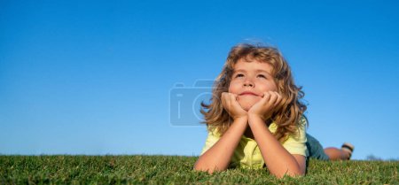 Téléchargez les photos : Child on spring nature background, horizontal photo banner for website header design. Happy child playing on green grass. Funny kid outdoor in spring garden. Children day concept - en image libre de droit