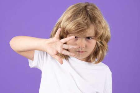 Photo for Portrait of kid boy making stop gesture on isolated studio background. Kid showing warning symbol, hand sign no. Kids protection, bullying, abuse and violence concept - Royalty Free Image
