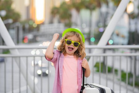 Foto de Child boy and travel suitcase. Kid with travel bad for vacation, child trip. Little tourist with suitcase. Child traveler and baggage. Kid with luggage bags going on holiday trip - Imagen libre de derechos