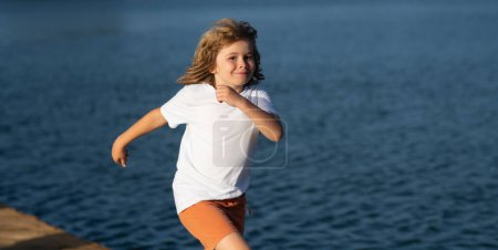 Foto de Niño corriendo al aire libre. Feliz infancia. Actividad deportiva saludable para niños. Niño en la carrera de atletismo. Corredor niños haciendo ejercicio - Imagen libre de derechos