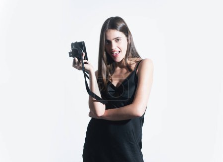 Téléchargez les photos : Portrait of pretty young woman with photo camera of photographer. Portrait of a sensual girl with a camera in hand on a white background. Isolated studio - en image libre de droit