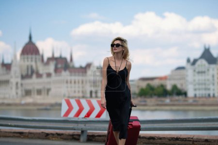Téléchargez les photos : Europe trip. Tourist sexy woman in Budapest. Traveler tourist girl in trendy dress with suitcase. Female model travel abroad weekends. Journey concept - en image libre de droit