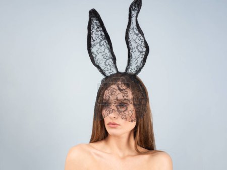 Téléchargez les photos : Belle femme sexy avec des oreilles de lapin sur fond de studio. Lapin festif et saison de Pâques. Femme sensuelle dans les oreilles de lapin de Pâques isolé sur fond de studio - en image libre de droit
