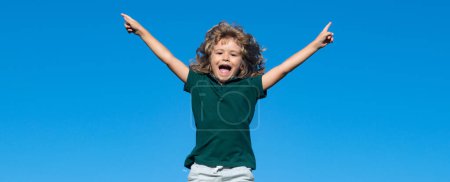 Téléchargez les photos : Portrait d'un petit garçon excité sur ciel bleu dans le parc - en image libre de droit