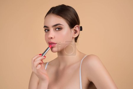 Photo for Lipstick, beauty and cosmetics. Beautiful woman applying lipstick on lips. Mockup for cosmetics, makeup. Lips color product, balm cosmetic on studio background - Royalty Free Image