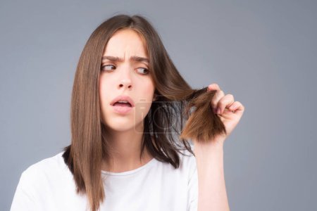 Photo for Woman with hair problem. Woman is looking shocked to her lost hair. Head bald and hair treatment concept - Royalty Free Image