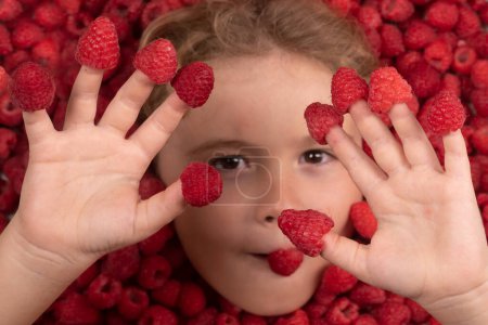 Photo for Summer fruits. Top view photo of child face in raspberries background. Healthy eating - Royalty Free Image
