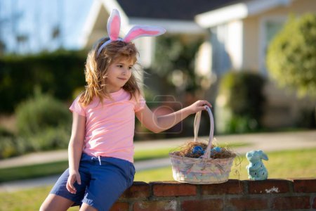 Téléchargez les photos : Joyeux Pâques. Enfants dans les oreilles de lapin avec oeuf de Pâques dans le panier. Garçon jouer dans la chasse oeufs. - en image libre de droit