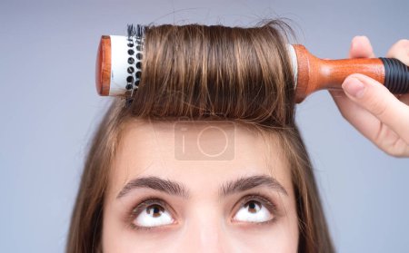 Téléchargez les photos : Belle femme peignant ses cheveux en studio - en image libre de droit