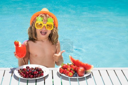 Téléchargez les photos : Cute kid in pool with summer fruits. Kids summer vacation. Beach and sea water fun. Summer vacation and holidays, healthy eating for kids. Funny amazed kids face - en image libre de droit