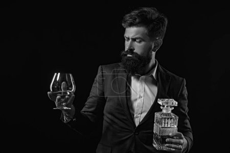 Photo for Bartender leather apron holding brandy snifter. Hipster with beard and mustache in suit drinks alcohol after working day - Royalty Free Image