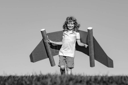 Foto de Piloto de niño con jetpack de juguete contra el fondo del cielo. Feliz niño jugando al aire libre. Feliz infancia. Concepto de imaginación infantil - Imagen libre de derechos