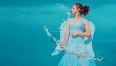 Photo for Teen cupid in white angels dress, valentine day with bow arrow shooting. Teenager angel with angels wings - Royalty Free Image
