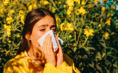 Photo for Woman with napkin fighting blossom allergie outdoor. Allergy to flowering. Young woman is going to sneeze. Sneezing and runny nose from pollen. Allergy medical seasonal flowers concept - Royalty Free Image