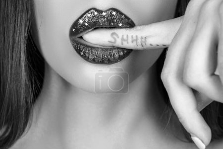 Foto de ¡Shh! Labios sexys. Brillante brillo de labios o lápiz labial. Secretos femeninos. Signo de silencio - Imagen libre de derechos