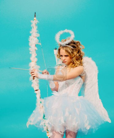 Photo for Cupid girl aiming at someone with an arrow of love. Arrow of love. Beauty blue her eyes - charming lady in the sunlight. Angel children girl with white wings. Happy Valentines day. - Royalty Free Image