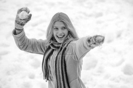 Photo for Happy young girl playing snowball fight. Portrait of a happy woman in the winter. Cheerful girl outdoors. Girl in mittens hold snowball - Royalty Free Image