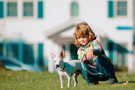 Téléchargez les photos : Enfant et chien de compagnie. Garçon enfant marcher avec chiot - en image libre de droit