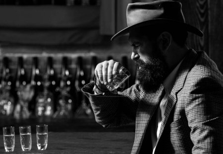 Photo for Handsome bearded man enjoying whiskey in bar. Hipster drinking in bar. Brutal guy drinking alcohol - Royalty Free Image