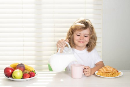 Photo for Pretten child pouring whole cows milk. Kid bot eating meal. Healthy nutrition for children. Child enjoy eating for breakfast or dinner with appetite. Hungry child eat tasty fruits and vegetables - Royalty Free Image