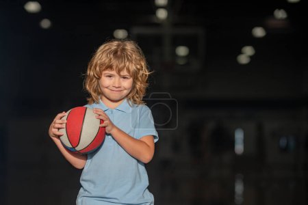 Téléchargez les photos : Mignon garçon enfant joue au basket. Enfants actifs appréciant le jeu en plein air avec ballon de basket - en image libre de droit