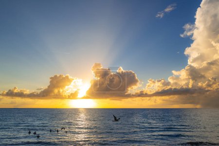 Foto de Puesta de sol en el mar con cielo y sol a través de las nubes. Fondo del océano y el cielo, paisaje marino. - Imagen libre de derechos