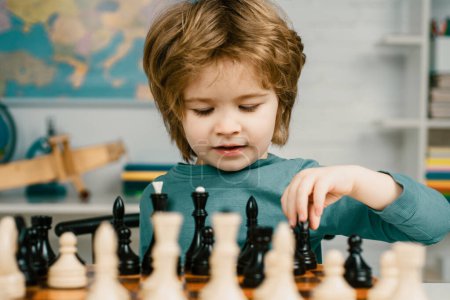 Téléchargez les photos : Enfant jouant aux échecs. Jeux éducatifs pour enfants, développement précoce des enfants. Intelligent concentré et pensant enfant tout en jouant aux échecs - en image libre de droit