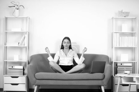 Téléchargez les photos : Femme d'affaires entrepreneure faisant de l'exercice de yoga sur le canapé sur le lieu de travail au bureau. Employé sentir équilibre harmonie relaxation. calme comptable fille méditation dans bureau - en image libre de droit