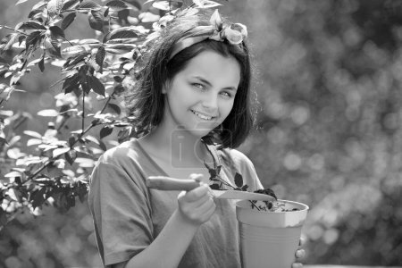 Photo for American farm life. Daughter grows flowers, potted. Happy little gardener with spring flowers. Little girl with pot. Watering pot - Royalty Free Image