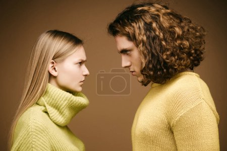 Foto de Joven pareja de moda. Foto de moda de pareja elegante en Studio. Retrato de pareja sobre fondo amarillo - Imagen libre de derechos