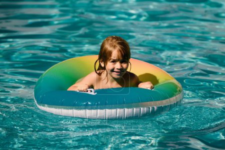 Téléchargez les photos : Joyeux enfant jouant avec anneau flotteur de natation dans la piscine. Vacances d'été. Mode de vie sain des enfants - en image libre de droit