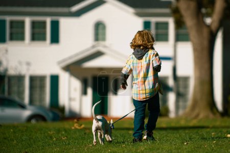 Foto de Un niño jugando con un cachorro. Niño feliz perro paseante - Imagen libre de derechos
