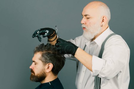 Téléchargez les photos : Salon de coiffure. Coloriage. Homme barbu en cours de coloration des cheveux. Appliquer de la couleur sur les cheveux et crier - en image libre de droit