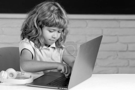 Photo for Child studying with digital devices. Kids boy student watching webinar on laptop - Royalty Free Image