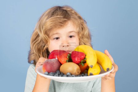 Téléchargez les photos : Assiette enfant drôle avec des fruits. Fruits et légumes pour enfants. Alimentation saine pour enfants - en image libre de droit