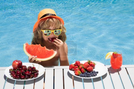 Photo for Kid relaxing on sea beach or pool. Kid with fruits and juice smoothie cocktail in summer pool. Child on summer vacation. Summer fruits for children - Royalty Free Image