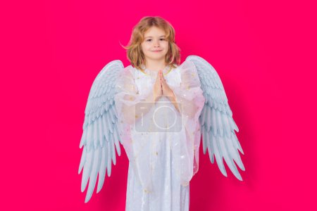 Photo for Angel prayer kids. Valentines day. Blonde cute child with angel wings on a yellow studio background. Happy angel child - Royalty Free Image