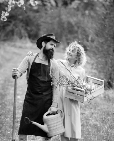 Foto de Un granjero y su esposa de pie en su campo. Pareja Farmars disfrutar de la naturaleza de primavera y cuidar de sus plantas. Concepto Tierra - Imagen libre de derechos