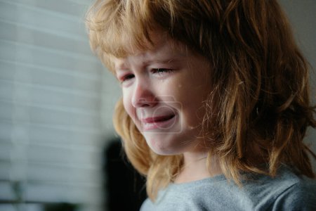 Foto de Rubia llora con lágrimas. Niño trastornado. Violencia en la familia sobre los niños. Concepto de bullying, estrés depresivo o frustración. Vista de cerca del chico. Pura emoción auténtica - Imagen libre de derechos