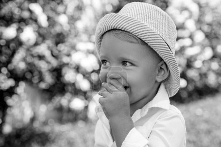 Téléchargez les photos : Enfant été marchant dans des vêtements décontractés. Joyeux garçon souriant dans le parc ou le jardin de printemps - en image libre de droit