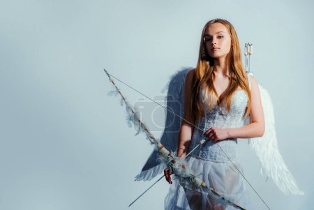 Foto de Día de San Valentín. ¡Valentine! Fondo blanco aislado. Cupido lindo ángel con arco y flechas - Concepto de San Valentín Día. Retrato de una niña cupido - Imagen libre de derechos